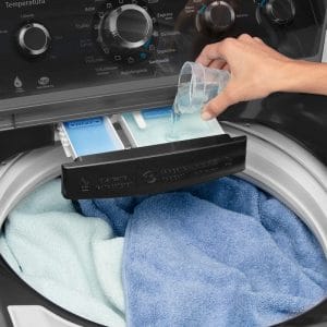 Una persona está lavando ropa en la Lavadora Automática Infusor 20 Kg Diamond Grey Mabe - LMC70203WDAB0.