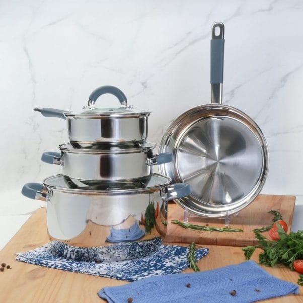 Un juego de BATERIA 7 PZAS ACERO INOX ACC SILICONA sobre tabla de cortar de madera. Un juego de BATERIA 7 PZAS ACERO INOX ACC SILICONA sobre tabla de cortar de madera.