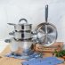 Un juego de BATERIA 7 PZAS ACERO INOX ACC SILICONA sobre tabla de cortar de madera.